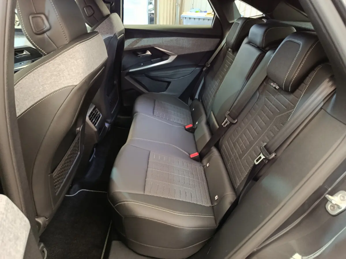 Vue côté droit de la banquette arrière en cuir noir et tissu gris du Peugeot 3008 1.2 Hybrid 145 GT 2025.