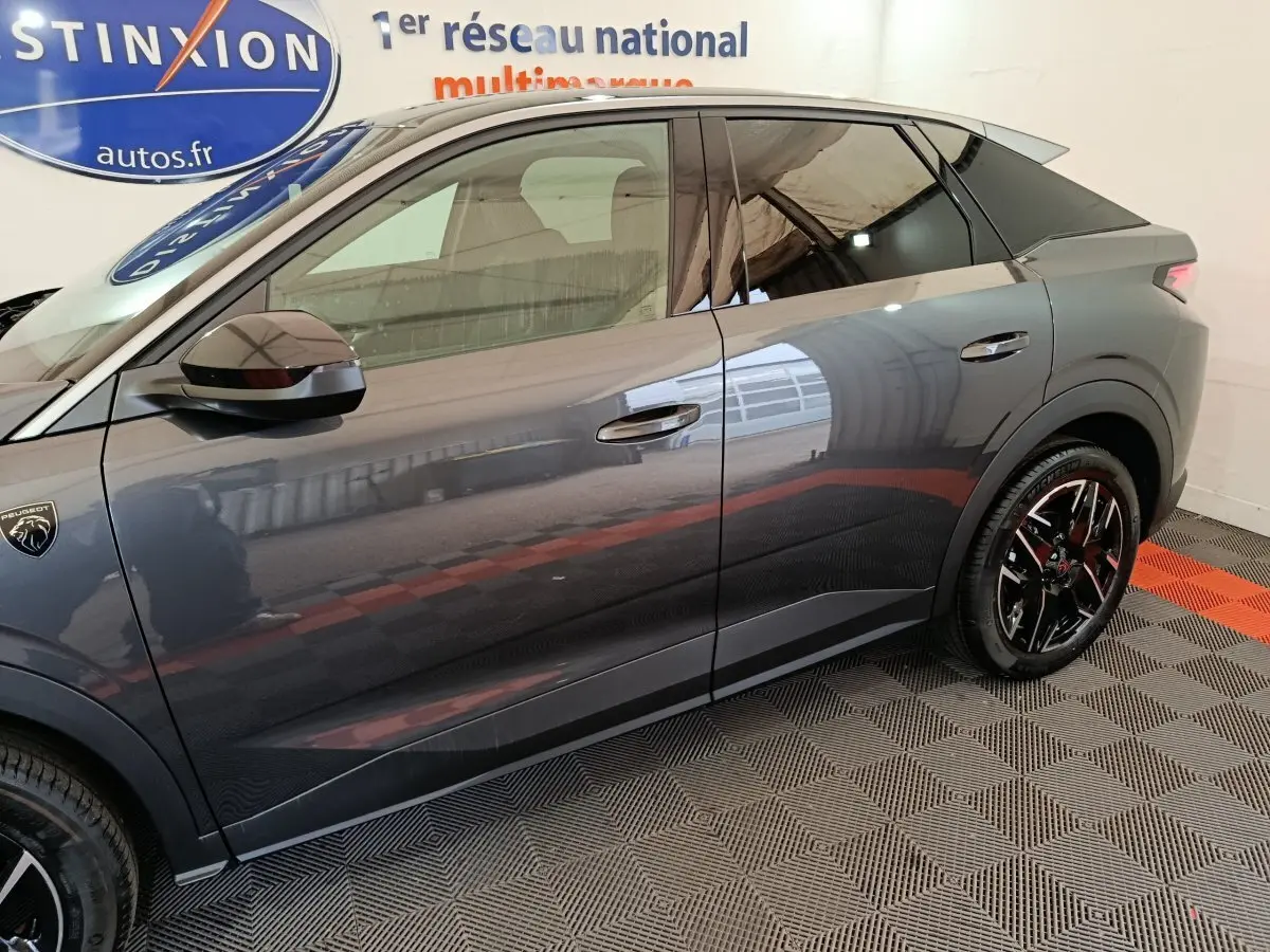 Profil côté gauche du Peugeot 3008 gris foncé 2025 avec jantes noires et logo lion visible sur l'aile avant.