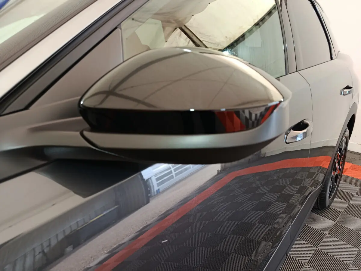 Rétroviseur côté gauche gris foncé du Peugeot 3008 2025, avec portière et jante partiellement visibles en arrière-plan.