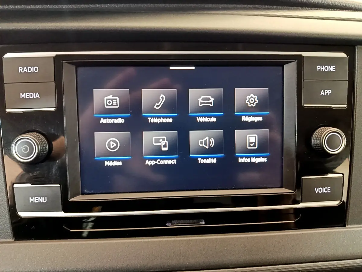 Écran tactile central du tableau de bord du Volkswagen Transporter 2.0 TDi blanc, affichant les options multimédias.