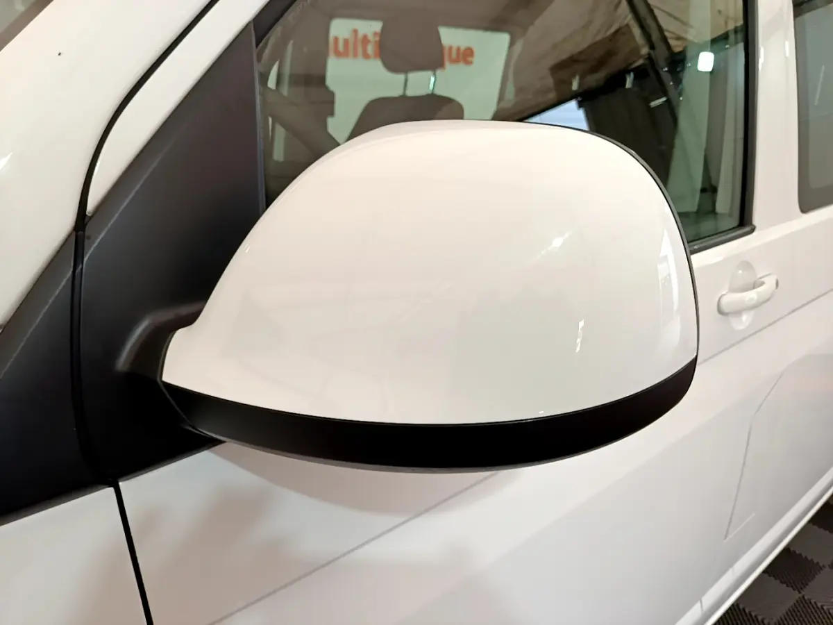 Gros plan sur le rétroviseur droit blanc du Volkswagen Transporter 2.0 TDi 150 DSG7 Business de 2021.