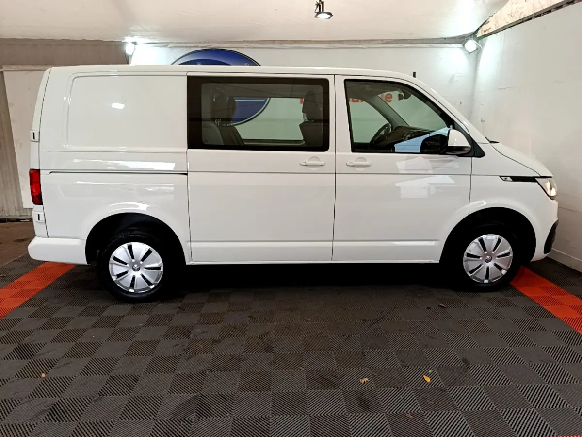 Vue latérale droite d'un Volkswagen Transporter blanc 2.0 TDi 150 DSG7 avec vitres avant teintées en intérieur.
