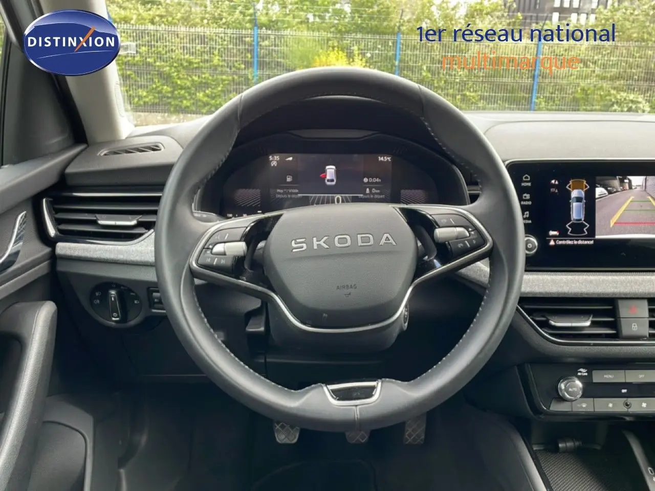 Vue frontale du volant SKODA SCALA 2025 avec tableau de bord numérique et écran central affichant la caméra de recul.