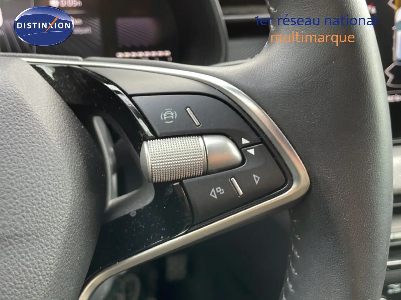 Gros plan sur les commandes multifonctions à droite du volant cuir noir de la Skoda Scala blanc glacier 2025.