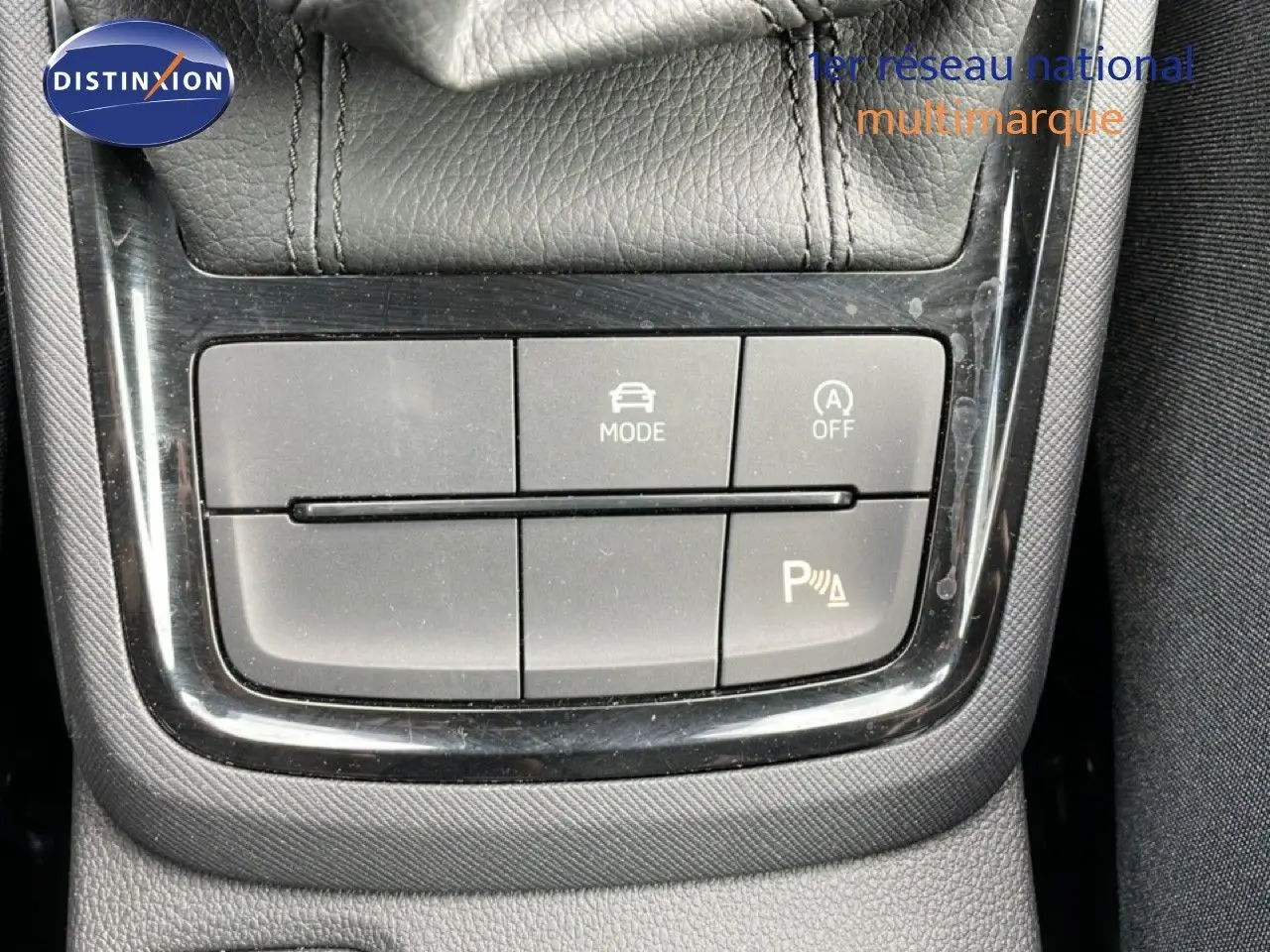 Gros plan sur les commandes de mode de conduite et d’aide au stationnement d’une Skoda Scala blanche Glacier.