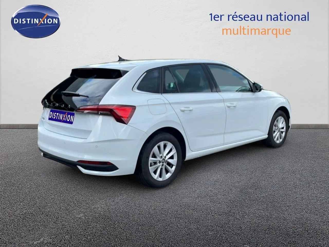 Vue 3/4 arrière droite d'une Skoda Scala blanche glacier avec toit noir et jantes alliage 16 pouces.