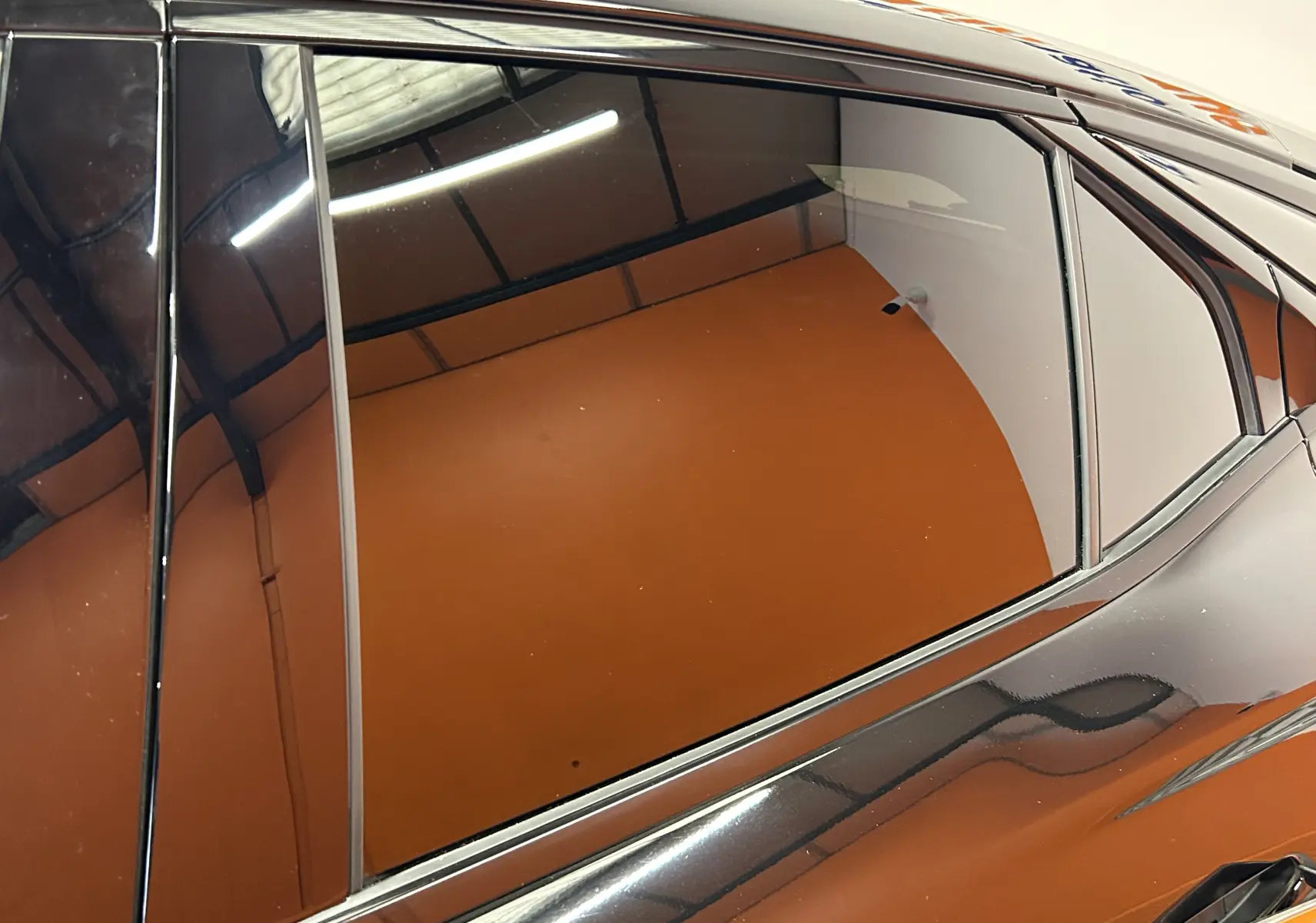 Gros plan sur la porte arrière côté gauche d'une DS4 2024 noire Perla Nera avec vitrage teinté et lignes de carrosserie élégantes.