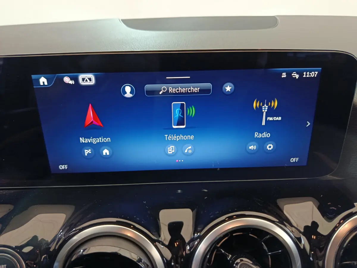 Écran tactile central bleu affichant navigation, téléphone et radio dans le tableau de bord du Mercedes GLA 250 e 2024.