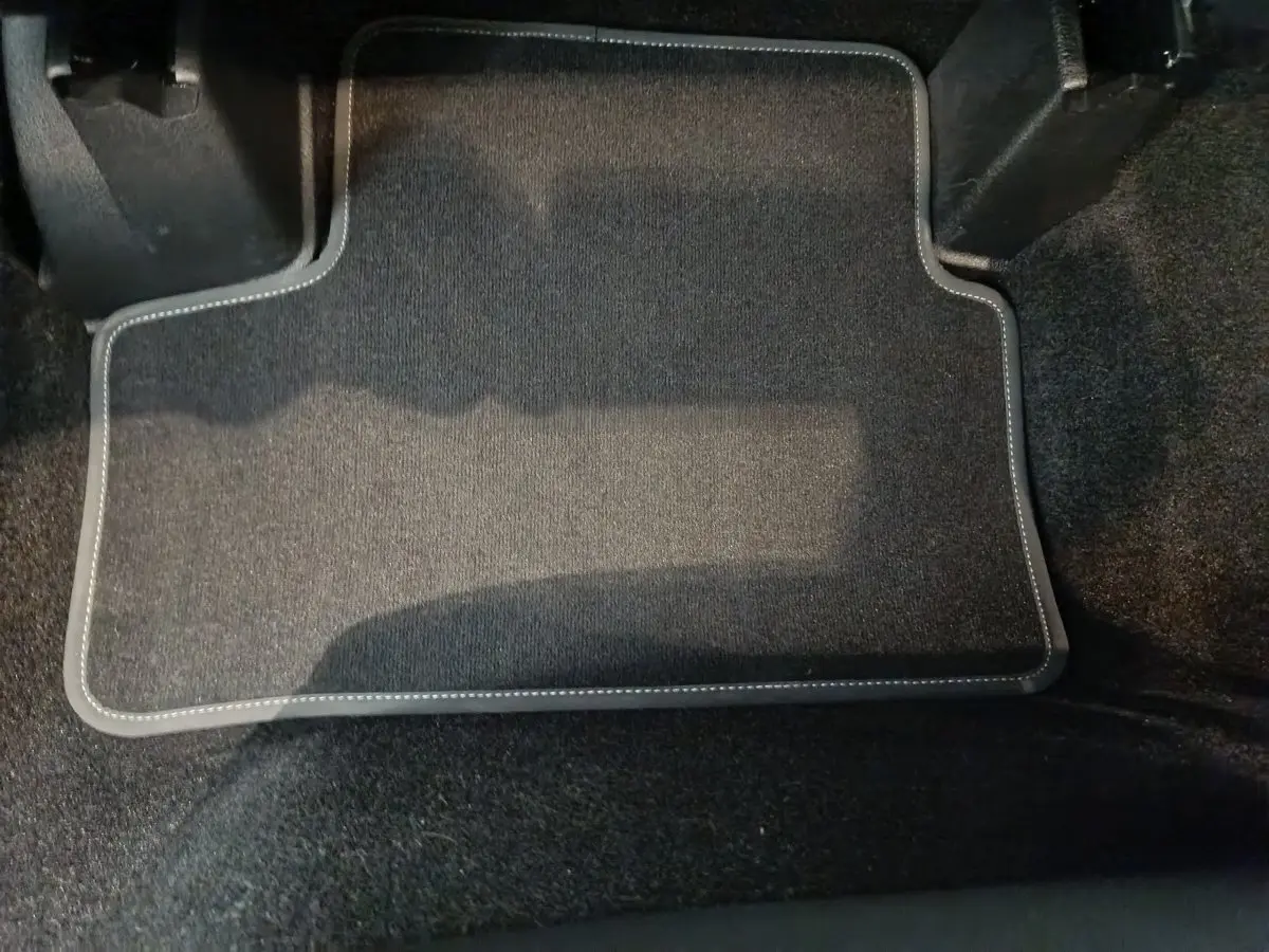 Tapis de sol noir avec surpiqûres blanches dans l'habitacle avant d'une Mercedes GLA 250 e Business Line 2024.