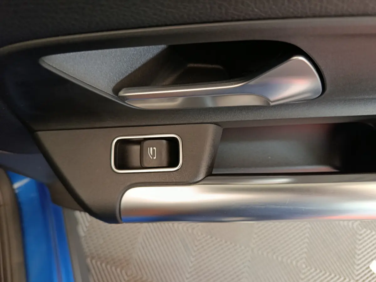 Gros plan sur la poignée intérieure côté gauche de la porte d’un Mercedes GLA 250 e Business Line bleu 2024.