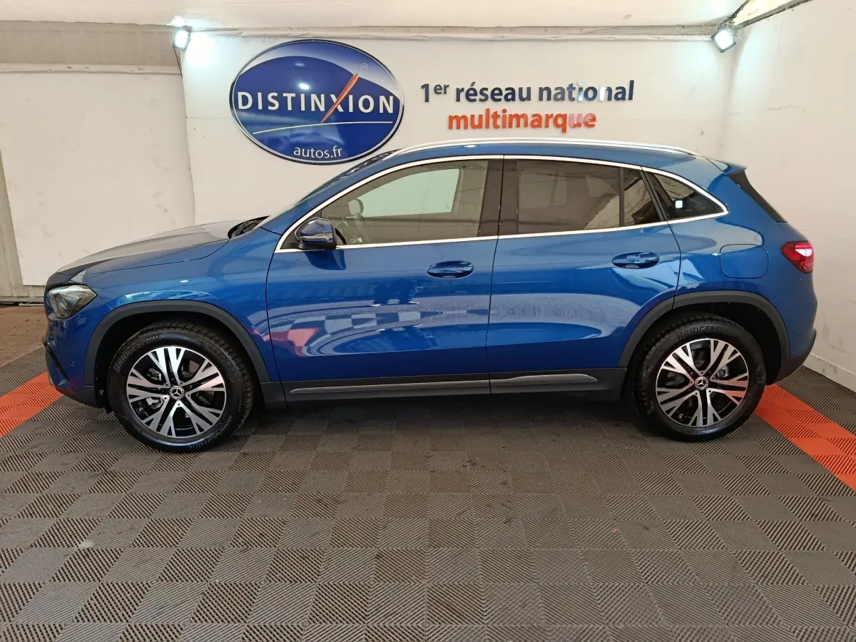 Vue de profil côté gauche d'un Mercedes GLA 250 e Business Line bleu 2024 avec jantes alliage et vitres teintées.