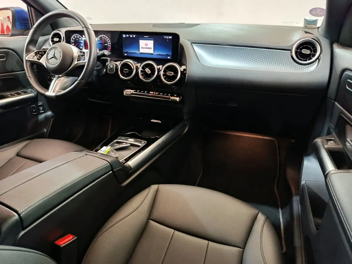 Intérieur noir du Mercedes GLA 250 e Business Line 2024, vue côté conducteur sur tableau de bord et volant cuir multifonctions.