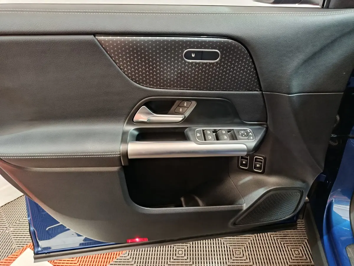 Porte intérieure côté gauche du Mercedes GLA 250 e Business Line 2024 en bleu, avec commandes fenêtres et verrouillage.