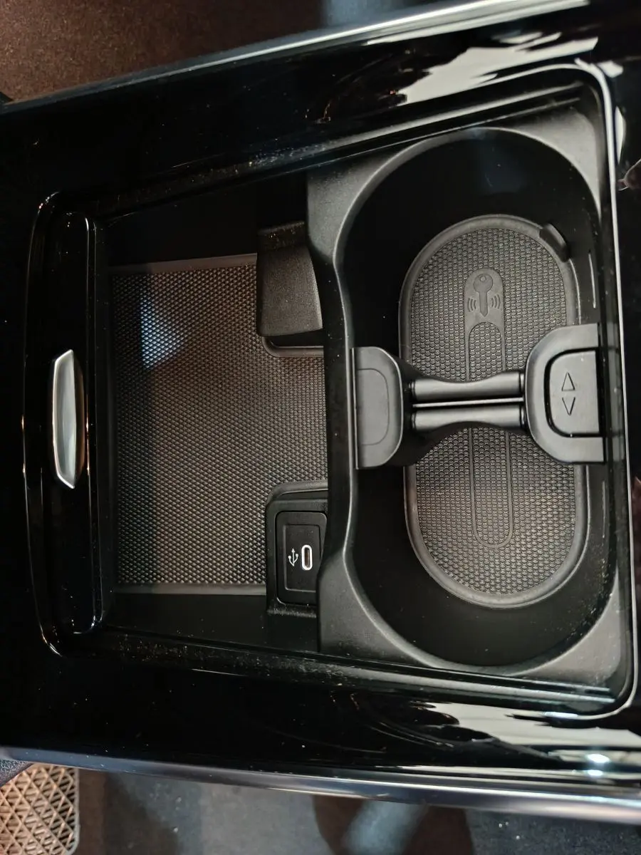 Gros plan sur le compartiment central noir du Mercedes GLA 250 e 2024 avec prise USB et support smartphone intégré.