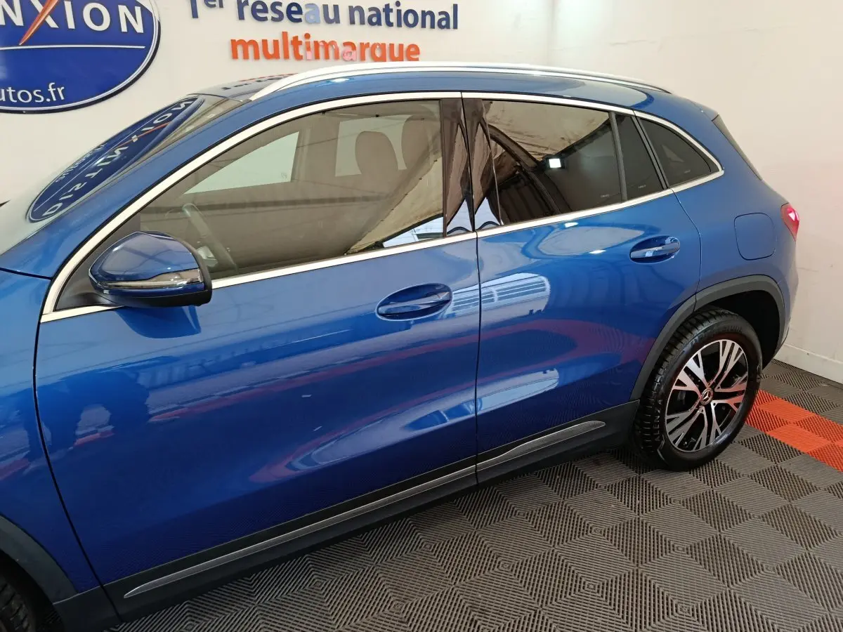 Vue latérale côté gauche d'un Mercedes GLA 250 e Business Line bleu avec jantes alliage et rétroviseurs chromés.