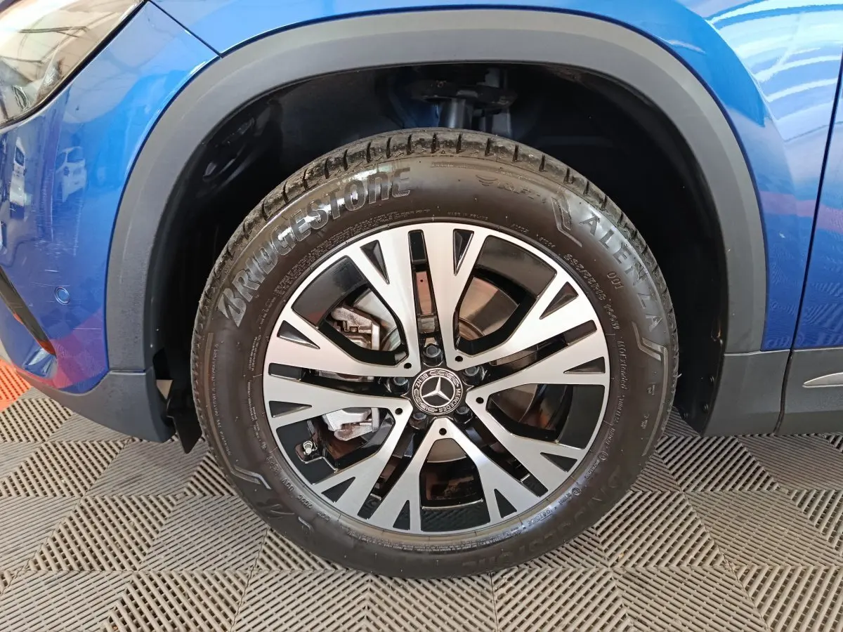 Gros plan sur la roue avant gauche du Mercedes GLA bleu 2024, mettant en valeur la jante alliage et le pneu Bridgestone.