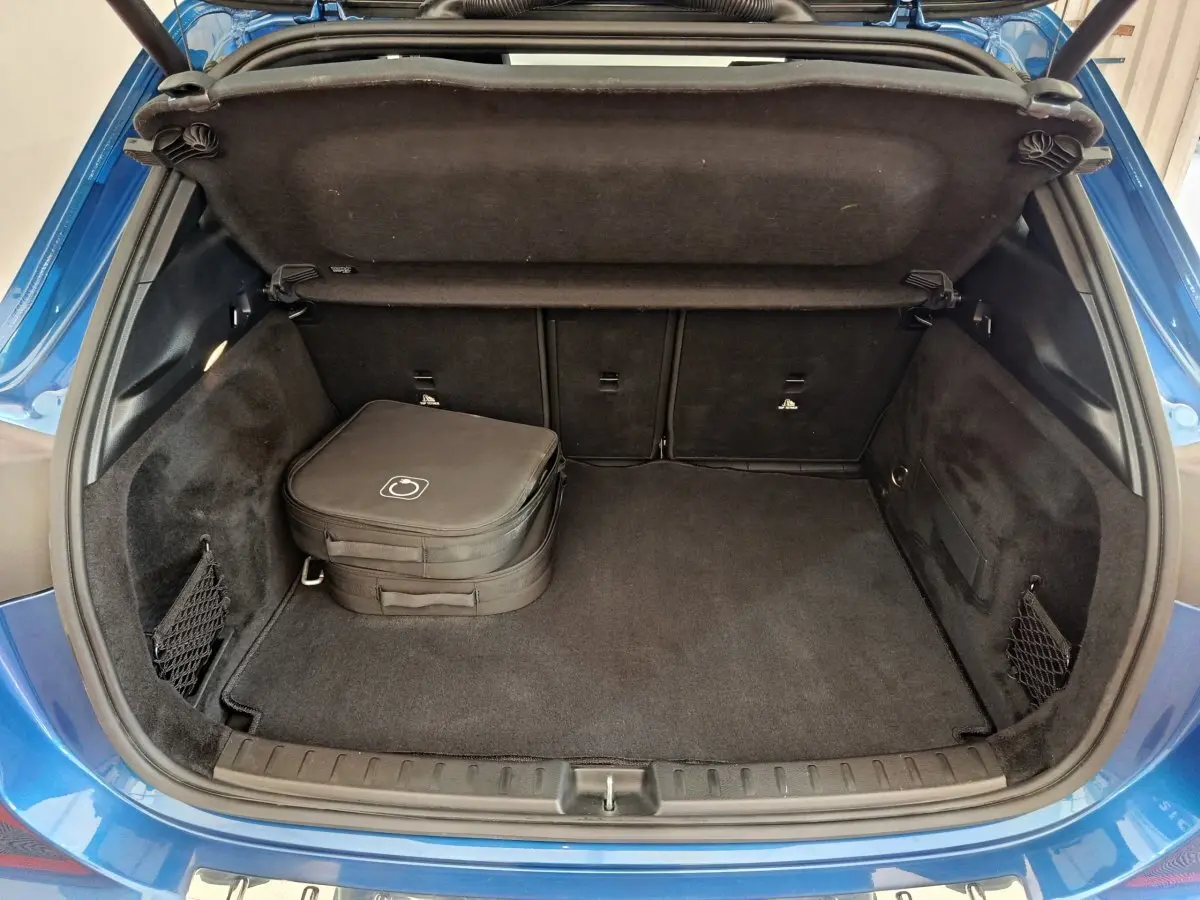 Coffre ouvert vu de l'arrière d'un Mercedes GLA 250 e Business Line bleu avec sac de rangement noir à l'intérieur.