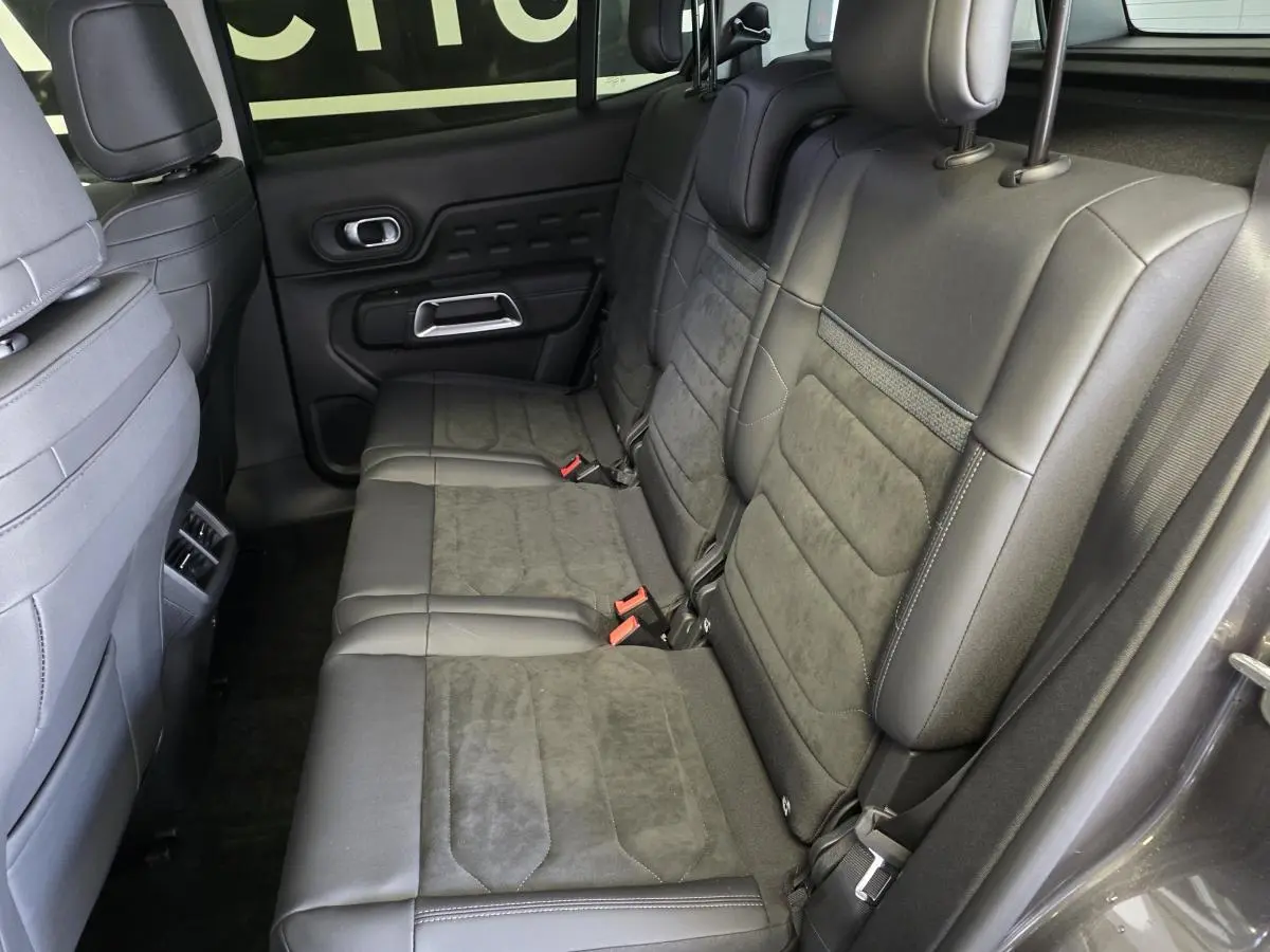 Vue latérale droite des sièges arrière gris cuir et tissu du Citroën C5 Aircross Hybrid 2024 avec appuis-tête réglables.
