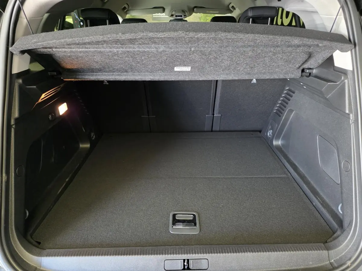 Coffre ouvert du Citroën C5 Aircross Hybrid gris, montrant le plancher plat et la tablette de séparation relevée.