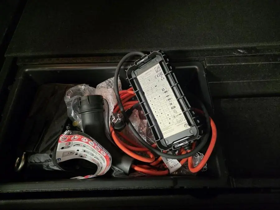 Chargeur électrique avec câble orange rangé dans le coffre du Citroën C5 Aircross Hybrid Rechargeable gris 2024