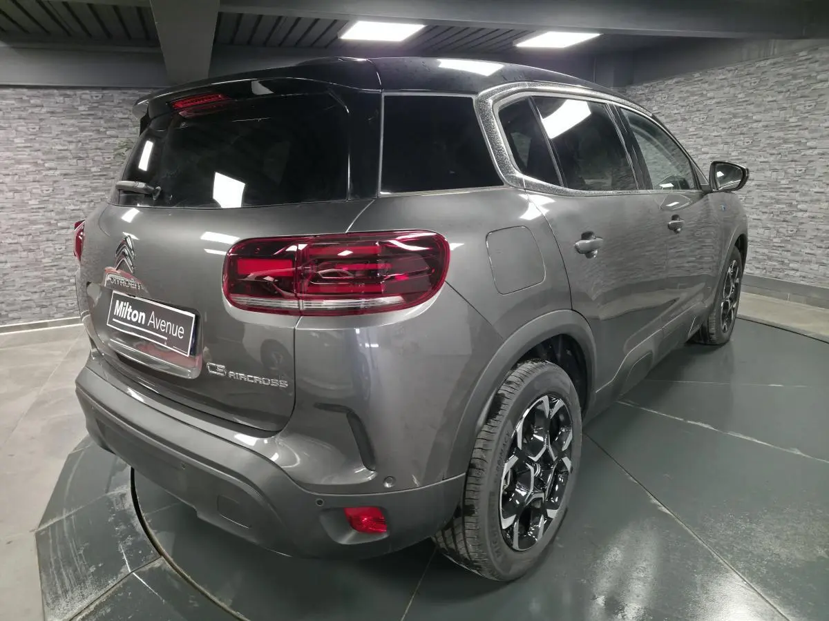 Vue 3/4 arrière droite du Citroën C5 Aircross gris avec toit noir et jantes alliage bi-ton.