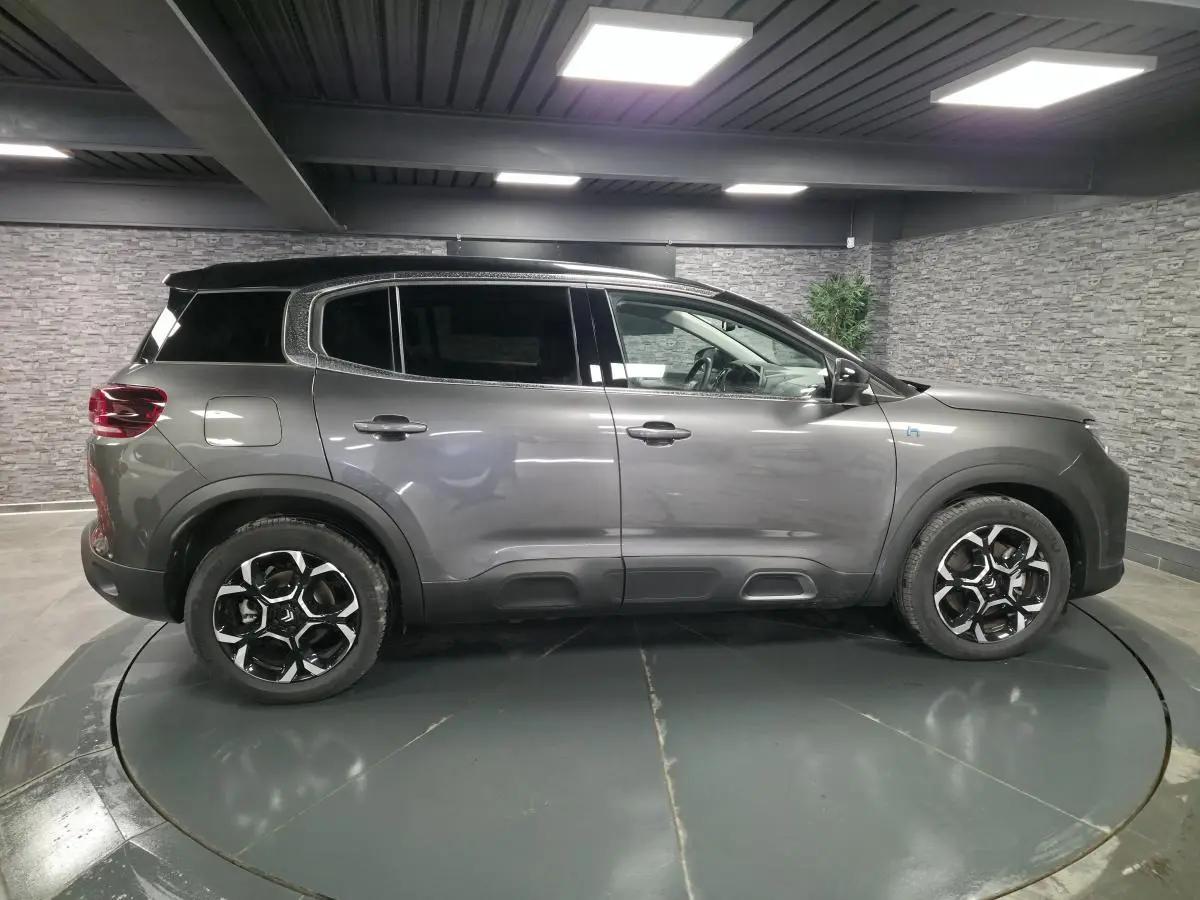 Profil droit du Citroën C5 Aircross Hybrid gris métallisé avec toit noir et jantes bi-ton 18 pouces.