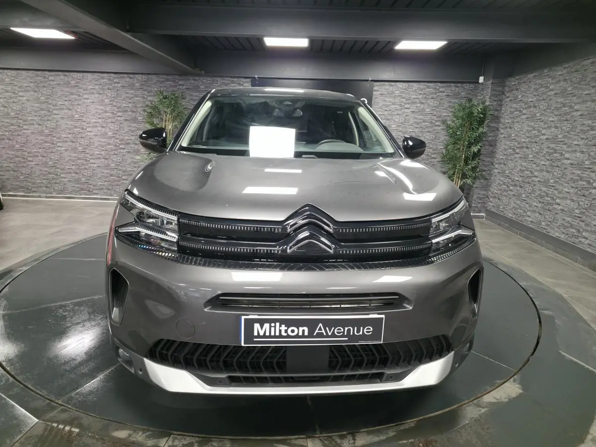 Vue frontale d'un Citroën C5 Aircross gris métallisé avec calandre noire brillante et logo double chevron chrome.