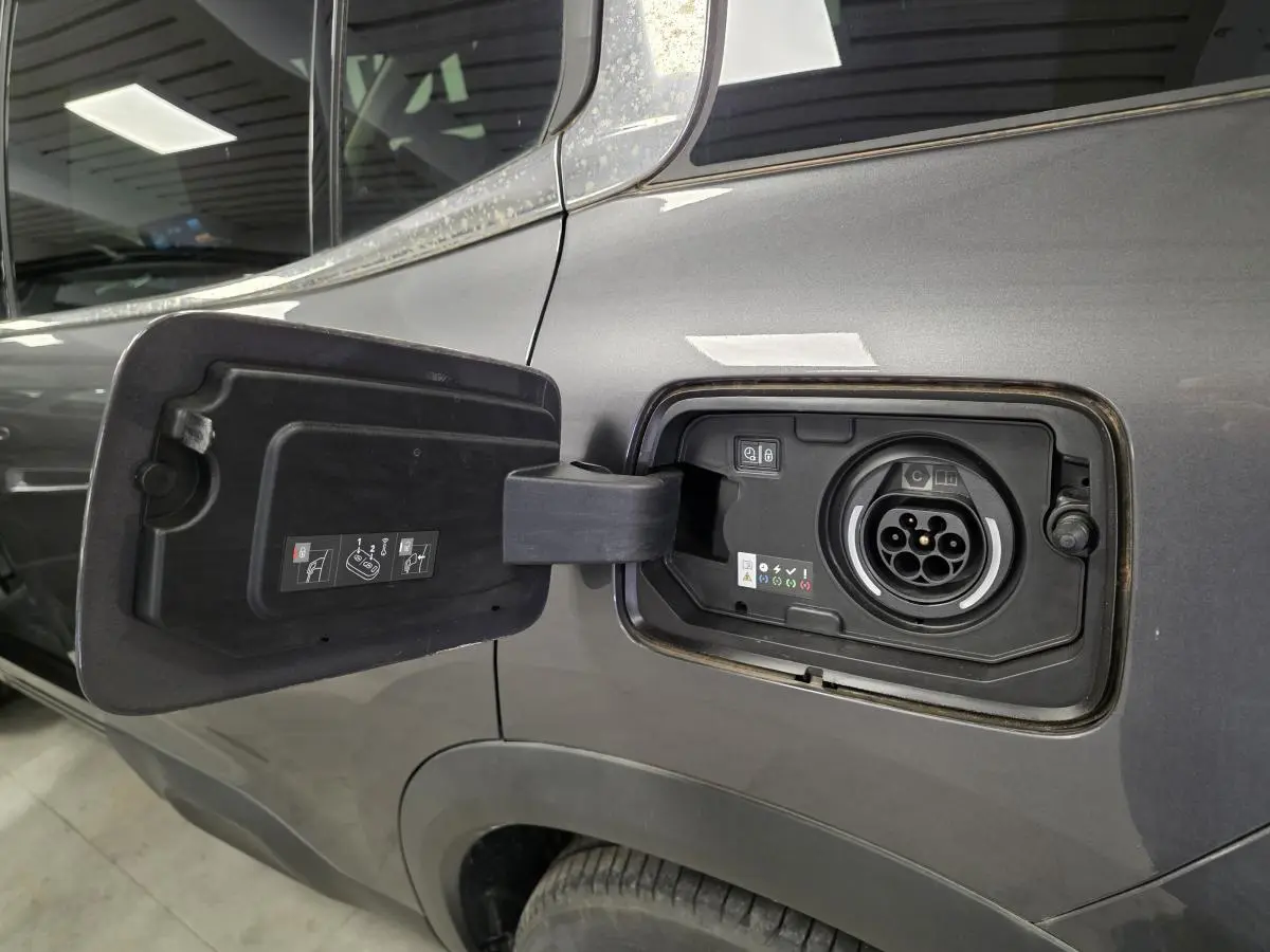 Prise de recharge hybride ouverte côté gauche d'un Citroën C5 Aircross gris métallisé 2024, détail du port de charge.