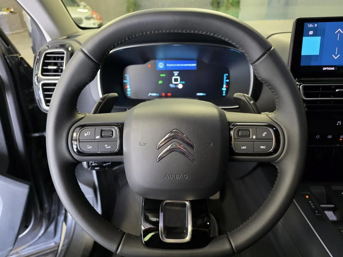 Volant cuir noir avec commandes intégrées et combiné numérique du Citroën C5 Aircross Hybrid 2024 vu de face.