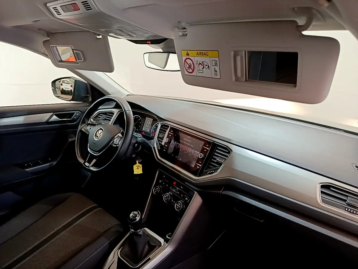 Vue intérieure côté conducteur du Volkswagen T-Roc 1.0 TSI 110 Lounge 2021, volant cuir et écran tactile central.