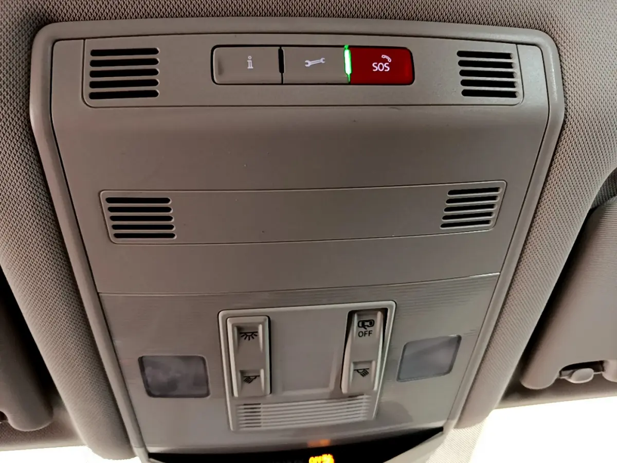 Vue intérieure du plafonnier gris clair du Volkswagen T-Roc 2021 avec boutons d’éclairage et alerte SOS rouge allumée.
