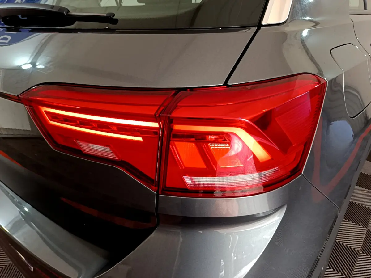 Gros plan sur le feu arrière droit rouge d’un Volkswagen T-Roc gris foncé, version 2021 essence.