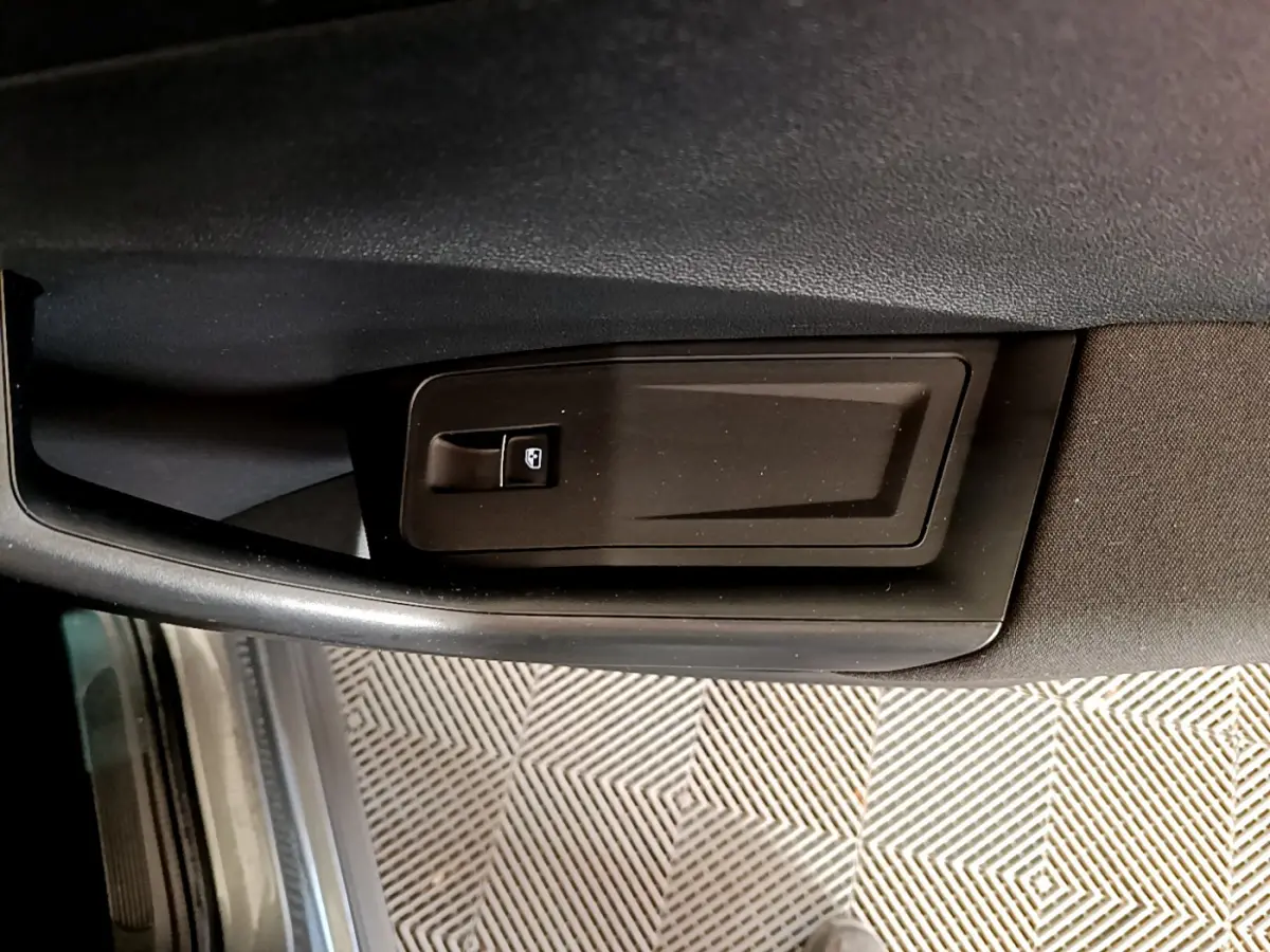 Détail de la commande de verrouillage de porte côté conducteur du Volkswagen T-Roc gris foncé, intérieur noir.