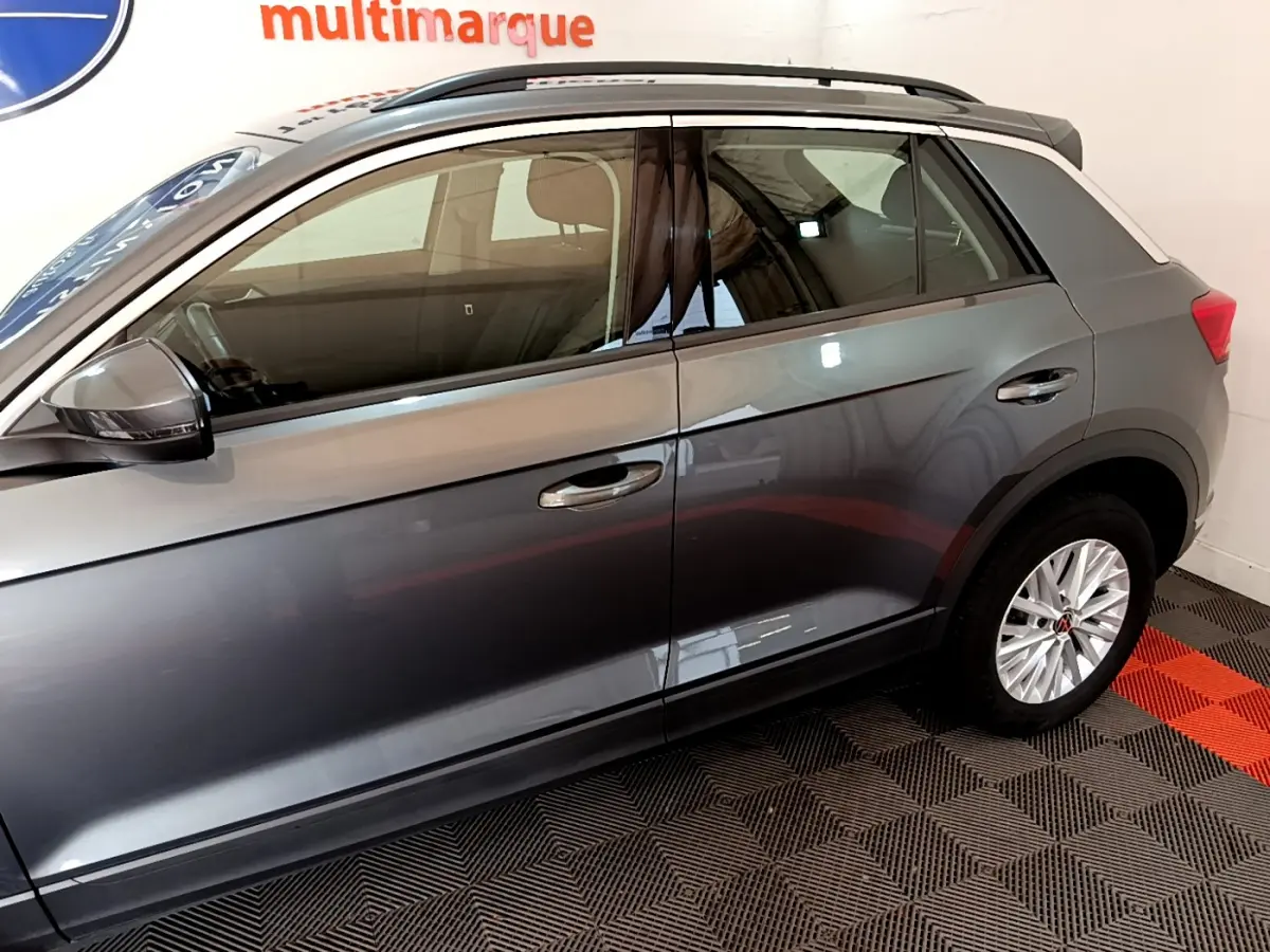 Vue latérale droite du Volkswagen T-Roc gris foncé 2021, soulignant les jantes alliage et les rétroviseurs noirs.