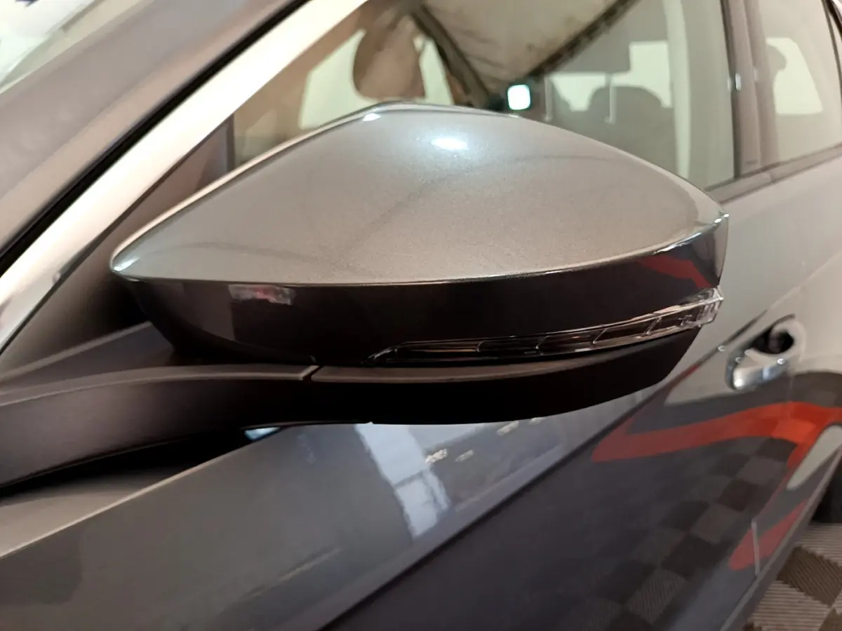 Gros plan sur le rétroviseur droit gris foncé du Volkswagen T-Roc 1.0 TSI 110 Lounge avec clignotant intégré.