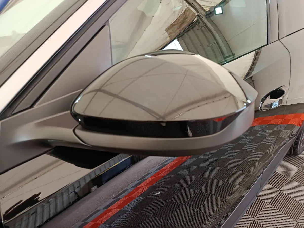 Rétroviseur côté gauche noir brillant du Peugeot 3008 1.2 HYBRID 145 E-DCS6 GT 2025 avec porte et poignée visibles.