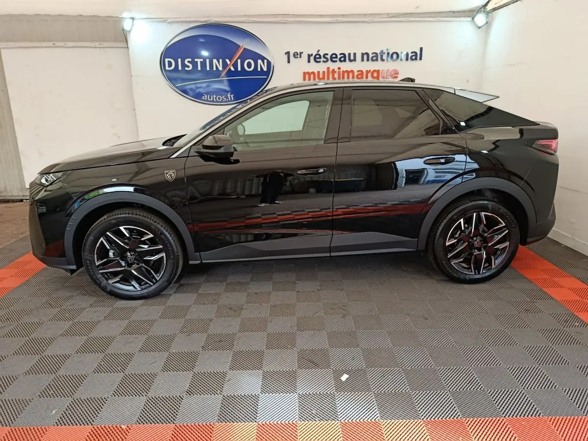 Profil côté gauche du Peugeot 3008 1.2 HYBRID 145 GT noir brillant dans un showroom multimarque.