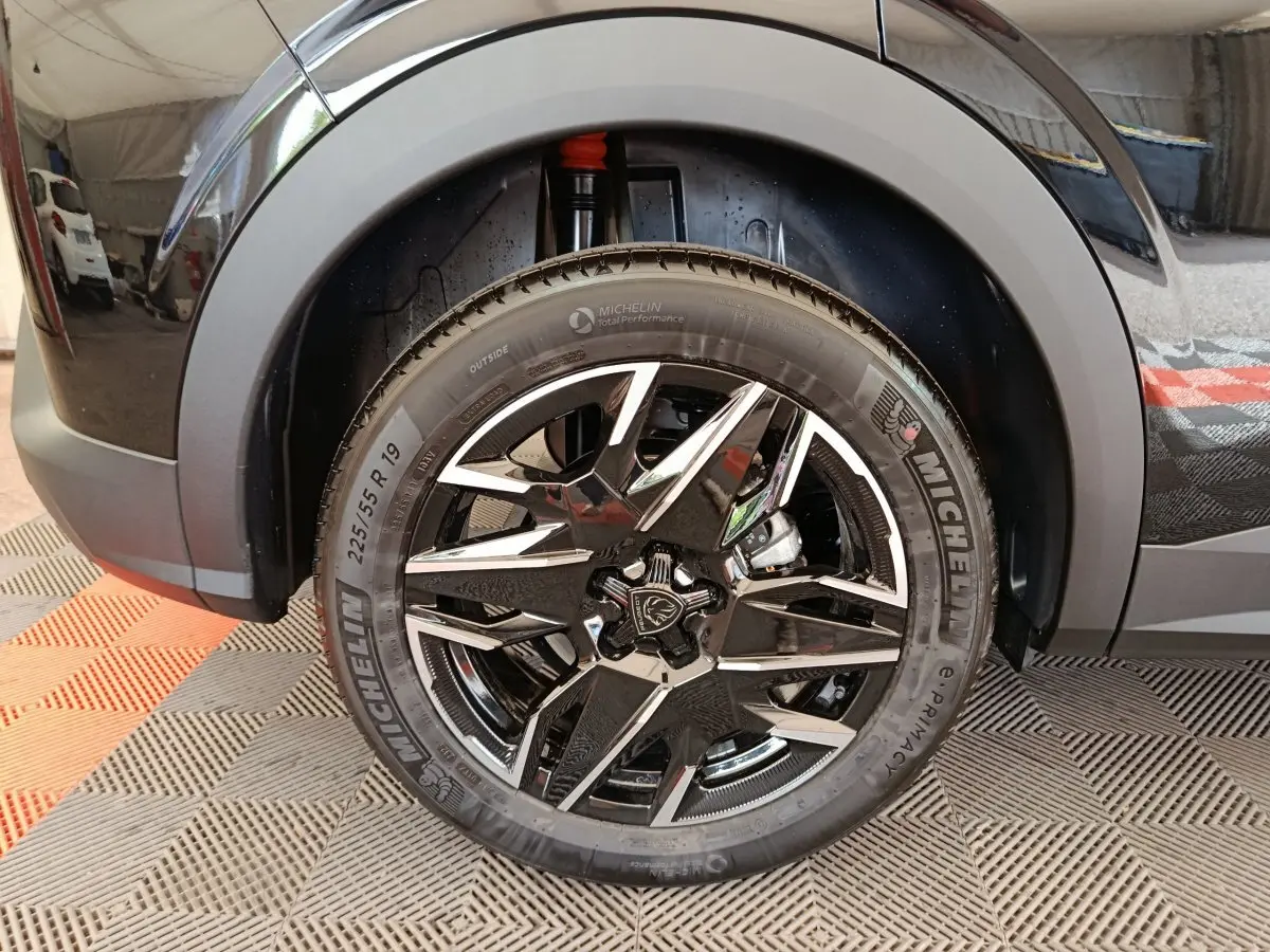 Gros plan sur la roue avant droite noire du Peugeot 3008 1.2 HYBRID 145 E-DCS6 GT avec jante alliage et pneu Michelin.
