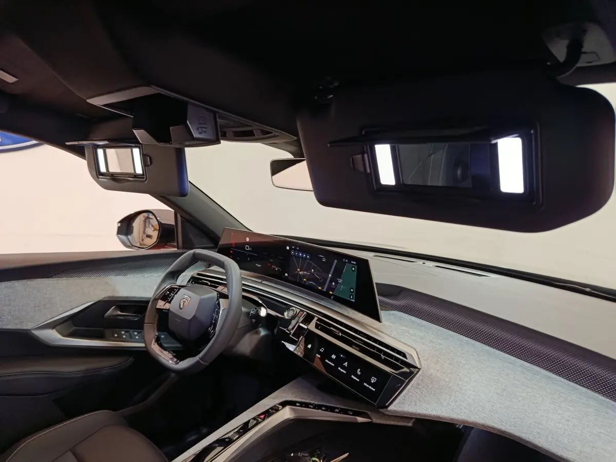 Intérieur du Peugeot 3008 noir, vue côté conducteur, tableau de bord moderne avec écran tactile panoramique et volant cuir.