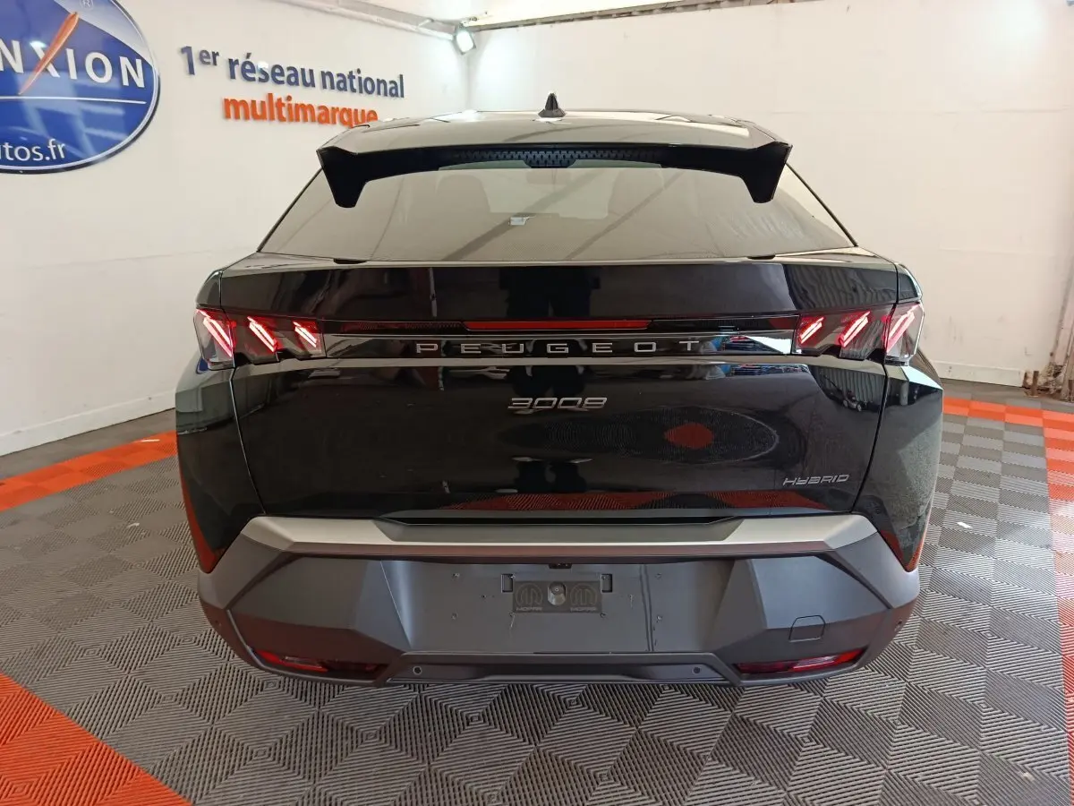 Vue arrière du Peugeot 3008 noir hybride 2025 avec feux LED caractéristiques et logo central lumineux.