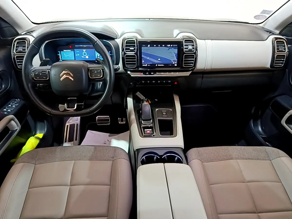 Vue intérieure avant du Citroën C5 Aircross Hybrid noir, montrant tableau de bord bicolore et écran tactile central.