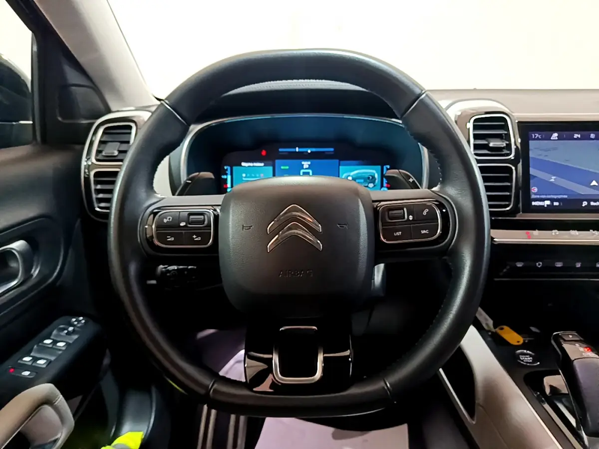 Vue intérieure centrée sur le volant cuir noir du Citroën C5 Aircross Hybrid avec tableau de bord digital et écran tactile.