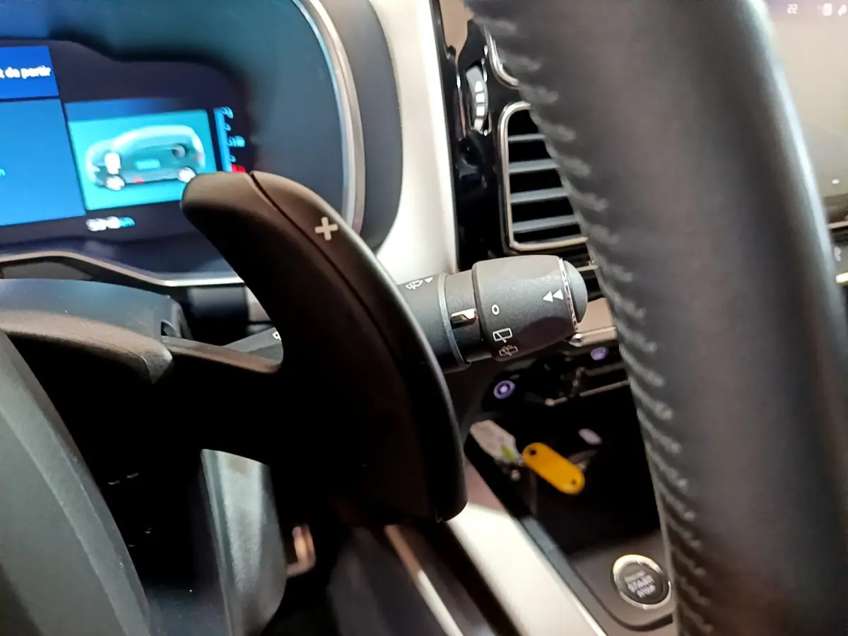 Gros plan sur la palette de changement de vitesse droite et le volant cuir noir du tableau de bord du Citroën C5 Aircross Hybrid.