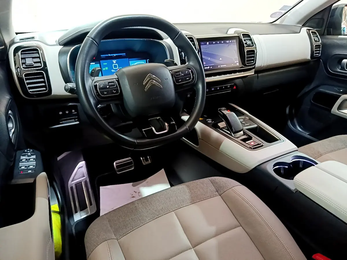 Vue intérieure avant du Citroën C5 Aircross Hybrid noir, avec tableau de bord digital et volant cuir multifonctions.