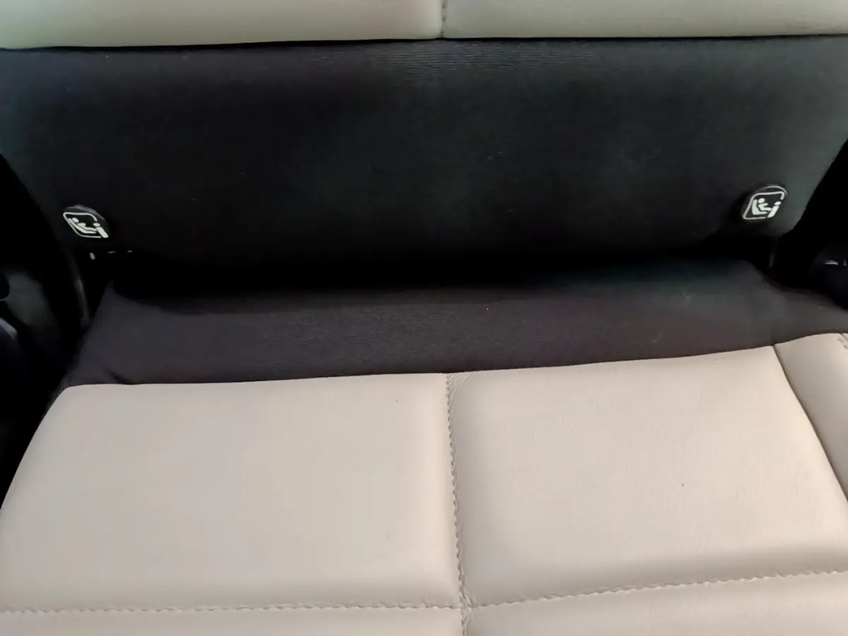 Détail des fixations Isofix sur la banquette arrière noire et beige du Citroën C5 Aircross Hybrid 225 ë-EAT8 Shine.