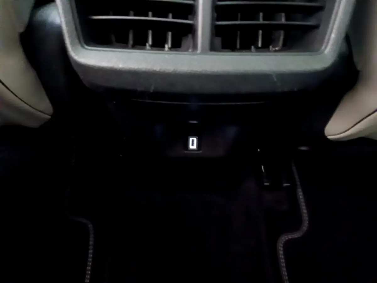 Vue rapprochée de la prise USB arrière sous les aérateurs, intérieur noir du Citroën C5 Aircross Hybrid 225 ë-EAT8 Shine.