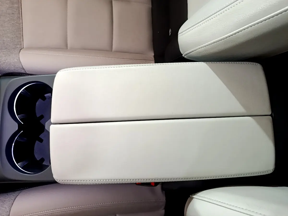 Vue plongeante sur l'accoudoir central beige et porte-gobelets du Citroën C5 Aircross Hybrid 225 ë-EAT8 Shine.