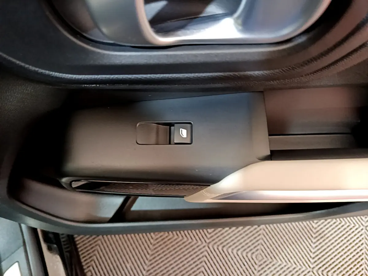 Détail du bouton de commande de vitre électrique sur la porte côté conducteur du Citroën C5 Aircross Hybrid noir.