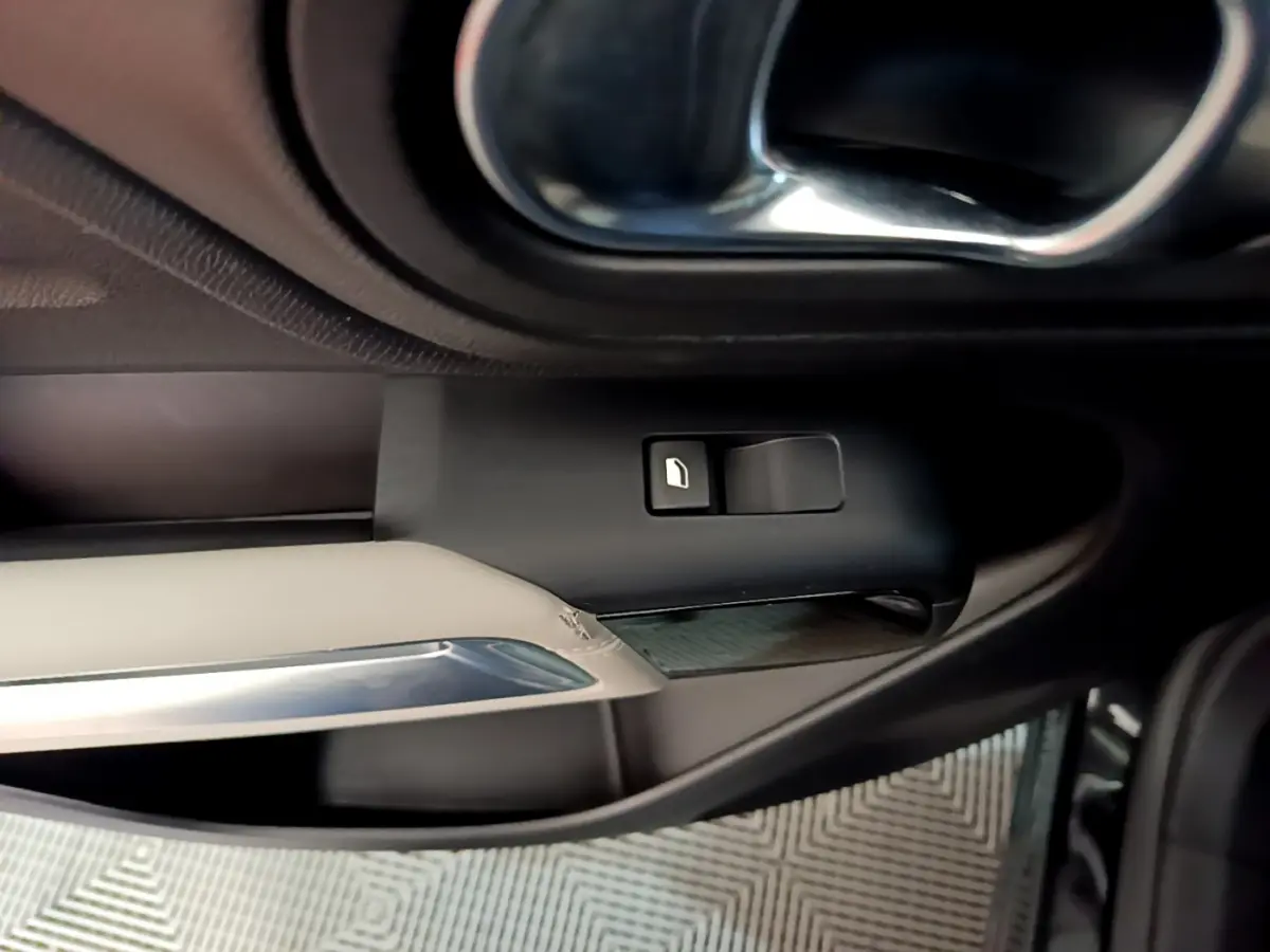 Détail de la poignée intérieure côté gauche avec bouton de verrouillage, finition noire et beige du Citroën C5 Aircross Hybrid.