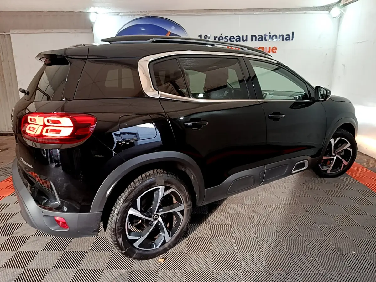 Vue 3/4 arrière droite d'un Citroën C5 Aircross Hybrid noir avec feux LED et jantes alliage distinctives.